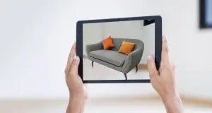 AR augmented reality. Hand holding digital tablet, AR application, simulate sofa furniture and and interior design